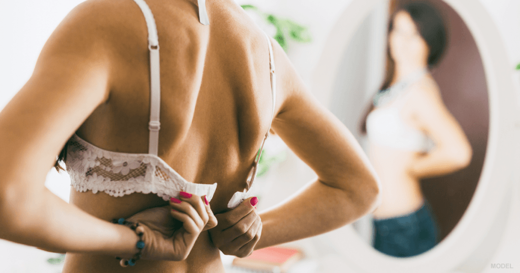 Woman putting on bra